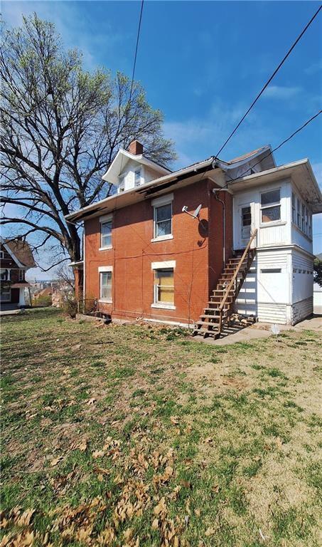 rear view of property with a yard