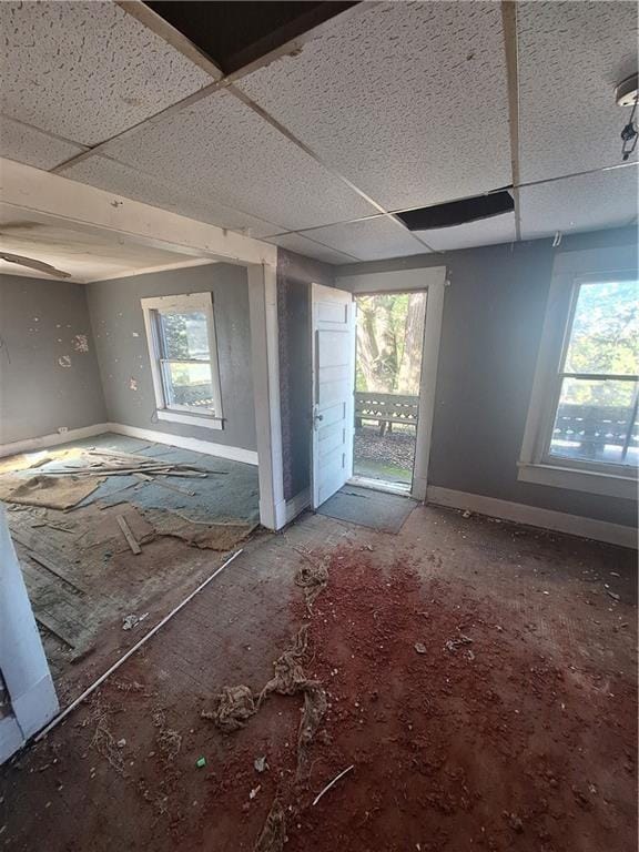 spare room featuring a paneled ceiling and plenty of natural light