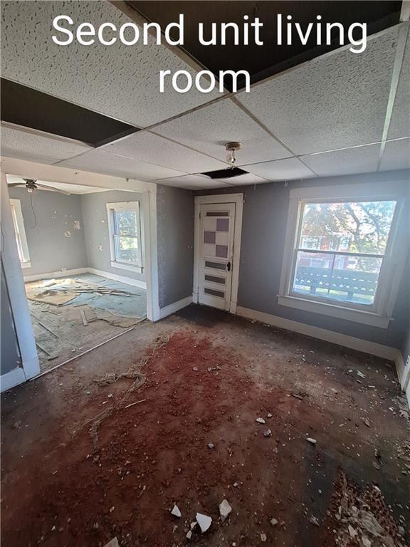 unfurnished living room with a paneled ceiling and ceiling fan