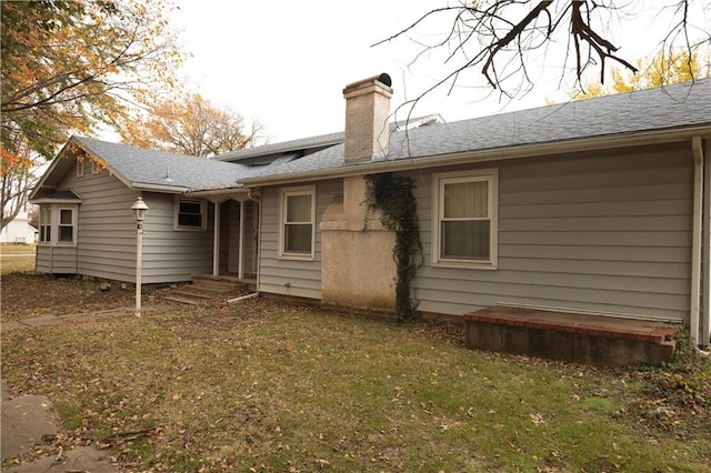 207 N Elm St, Coffeyville, KS 67337 - rear view of property with a chimney, a yard, and roof with shingles