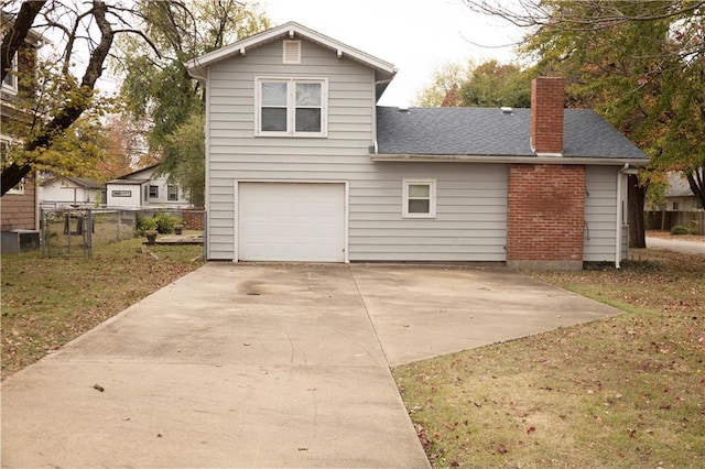 207 N Elm St, Coffeyville, KS 67337 - view of front of house with a chimney, driveway, an attached garage, and a shingled roof