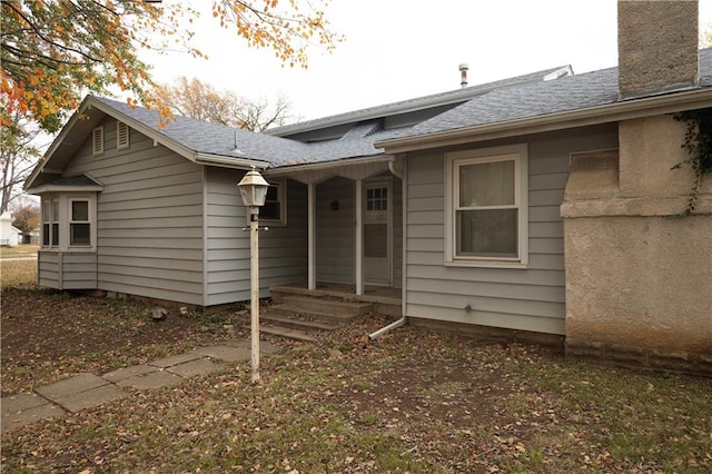 207 N Elm St, Coffeyville, KS 67337 - back of property featuring a chimney and roof with shingles