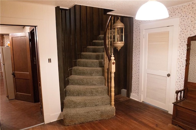 207 N Elm St, Coffeyville, KS 67337 - stairway featuring wood finished floors, wallpapered walls, and crown molding