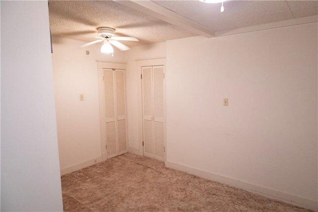 carpeted empty room with ceiling fan and a textured ceiling