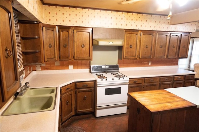 207 N Elm St, Coffeyville, KS 67337 - kitchen with white range with gas cooktop, a sink, open shelves, wooden counters, and under cabinet range hood