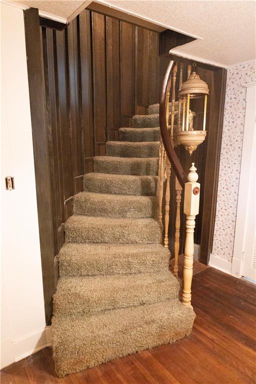 staircase featuring wood-type flooring and a textured ceiling