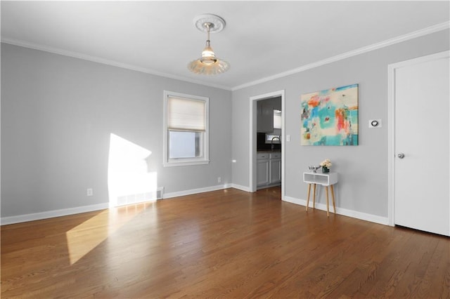 spare room featuring ornamental molding, dark hardwood / wood-style flooring, and sink