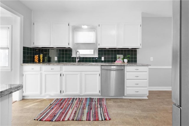 kitchen with backsplash, white cabinetry, dishwasher, and light stone countertops