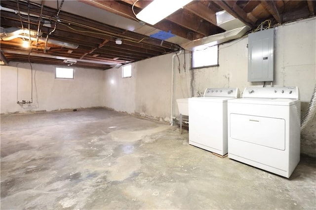 basement featuring sink, electric panel, and separate washer and dryer