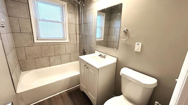 full bathroom with toilet, vanity, tiled shower / bath combo, and hardwood / wood-style flooring