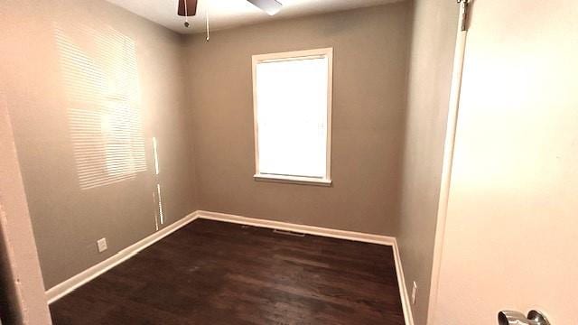 empty room with dark hardwood / wood-style flooring and ceiling fan