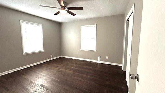 unfurnished room featuring a textured ceiling, dark hardwood / wood-style flooring, and ceiling fan