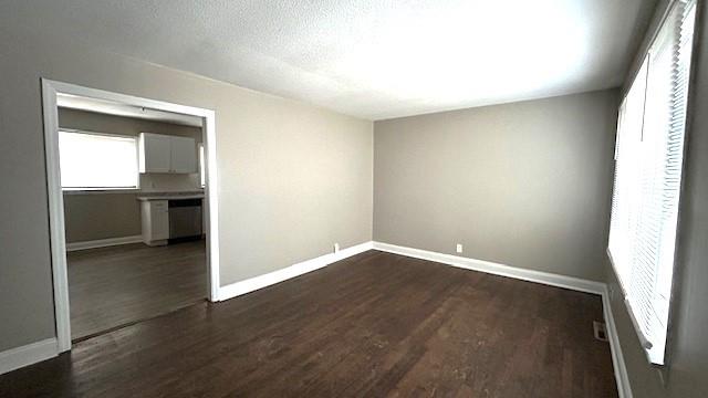 empty room featuring dark hardwood / wood-style floors and a textured ceiling