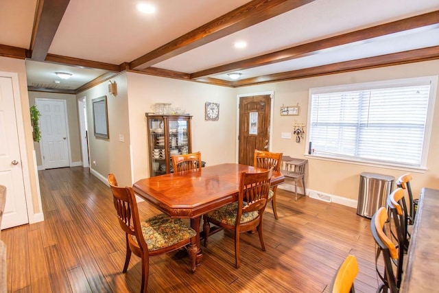 dining space featuring beam ceiling and wood-type flooring