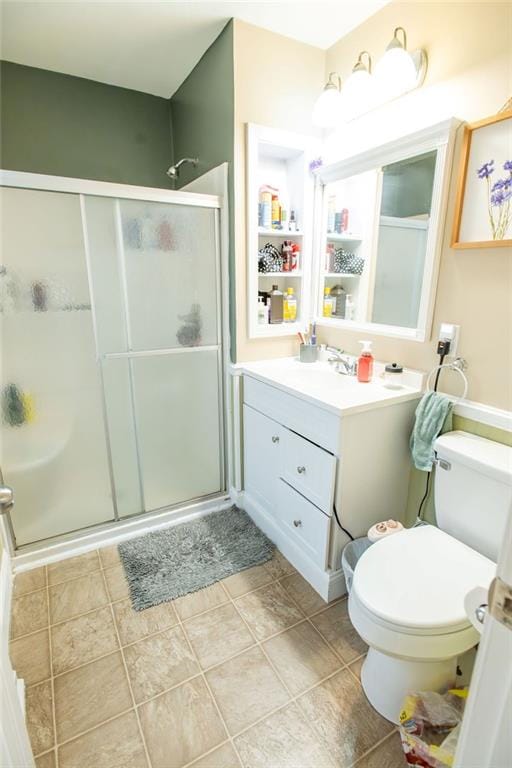 bathroom featuring tile patterned floors, vanity, toilet, and walk in shower