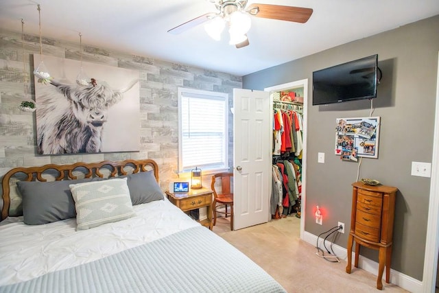 bedroom featuring a closet, a spacious closet, ceiling fan, and light colored carpet