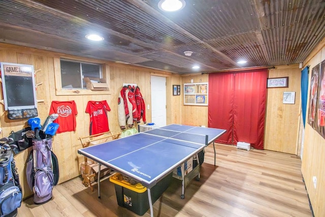 rec room featuring wood walls and light wood-type flooring