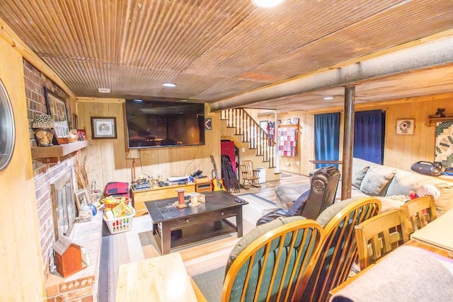 living room with a brick fireplace, wooden ceiling, and wood walls