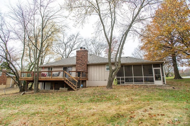 back of house featuring a sunroom, a lawn, and a wooden deck