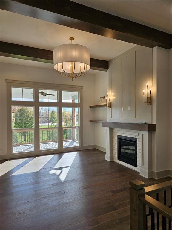 unfurnished living room featuring ceiling fan, beam ceiling, dark hardwood / wood-style flooring, and a fireplace