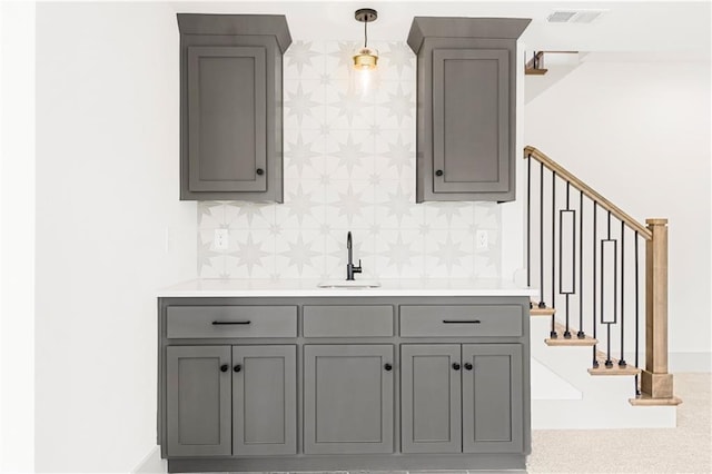 bar with a sink, visible vents, stairway, backsplash, and decorative light fixtures