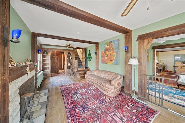 living room featuring hardwood / wood-style floors, beam ceiling, and radiator heating unit