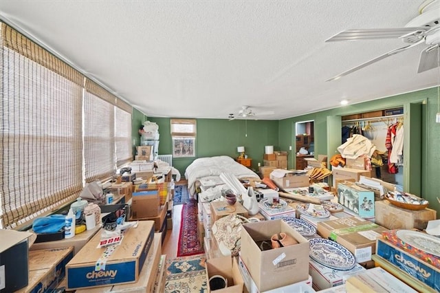 miscellaneous room with ceiling fan and a textured ceiling