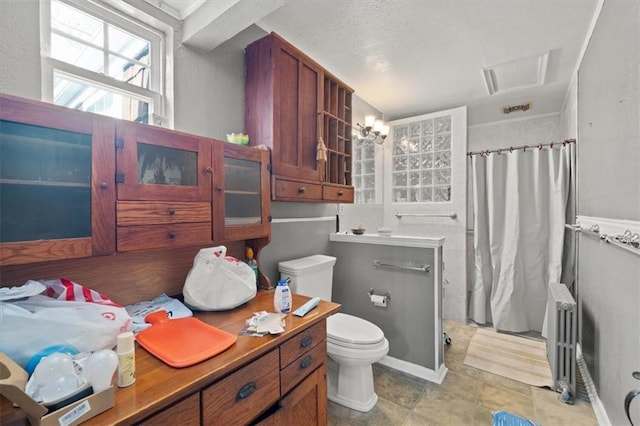 bathroom with radiator heating unit, toilet, and curtained shower