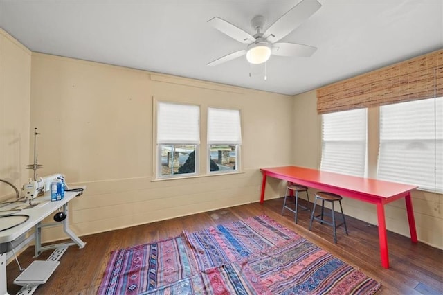 office area with dark hardwood / wood-style flooring, plenty of natural light, wood walls, and ceiling fan