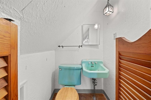 bathroom with a textured ceiling and lofted ceiling