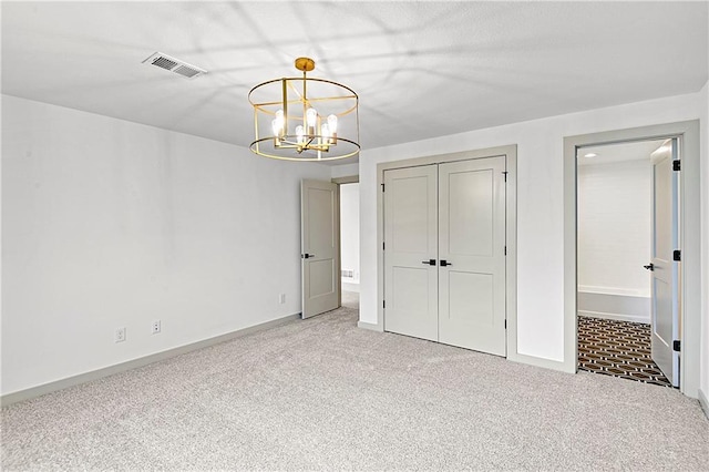 unfurnished bedroom with carpet, an inviting chandelier, and a closet