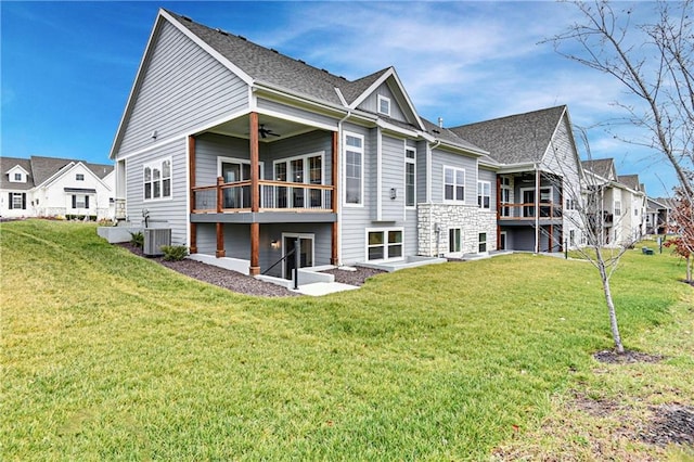 rear view of house featuring ceiling fan, a lawn, and central air condition unit