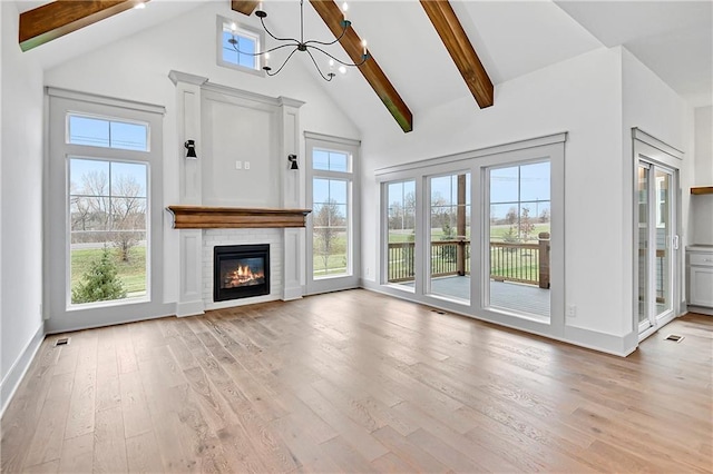 unfurnished living room featuring beam ceiling, light hardwood / wood-style flooring, high vaulted ceiling, and an inviting chandelier