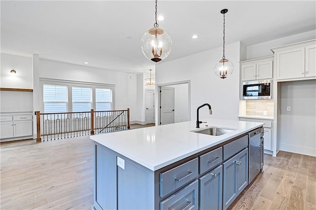 13465 W 174th Pl, Overland Park, KS 66221 - kitchen with appliances with stainless steel finishes, white cabinetry, light wood-style flooring, light countertops, and pendant lighting
