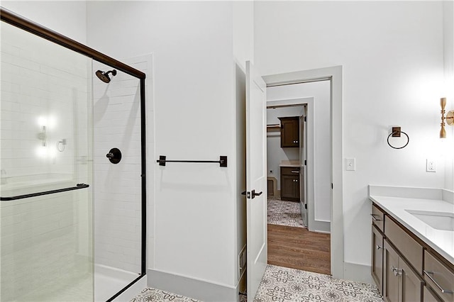 bathroom with vanity, hardwood / wood-style flooring, and a shower with shower door