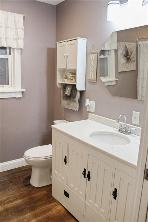 bathroom featuring a shower with shower curtain, wood-type flooring, vanity, and toilet