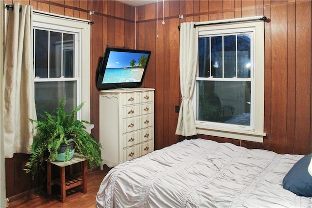 bedroom featuring wooden walls and hardwood / wood-style flooring