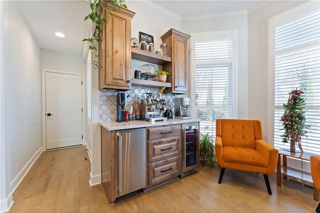 bar featuring tasteful backsplash, crown molding, light hardwood / wood-style floors, wine cooler, and stainless steel refrigerator