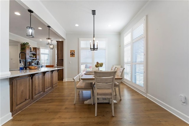 dining space with dark hardwood / wood-style flooring, a wealth of natural light, and crown molding