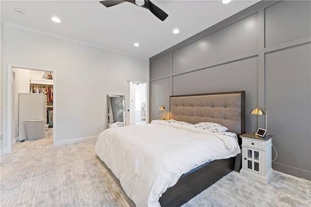 carpeted bedroom featuring a closet, ceiling fan, crown molding, and a spacious closet