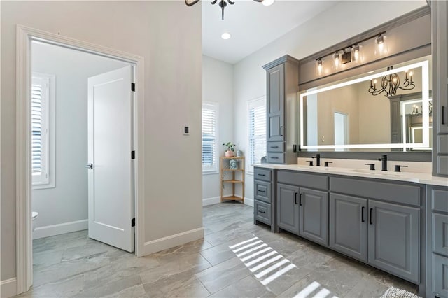 bathroom featuring toilet, vanity, and an inviting chandelier