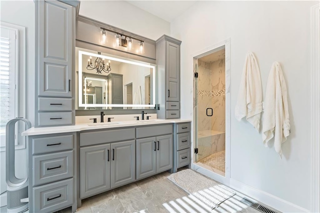 bathroom with vanity, a shower with shower door, and an inviting chandelier