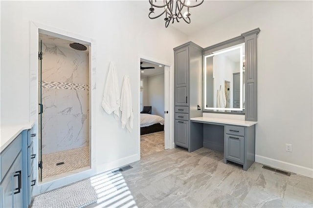 bathroom with vanity, tiled shower, and ceiling fan with notable chandelier