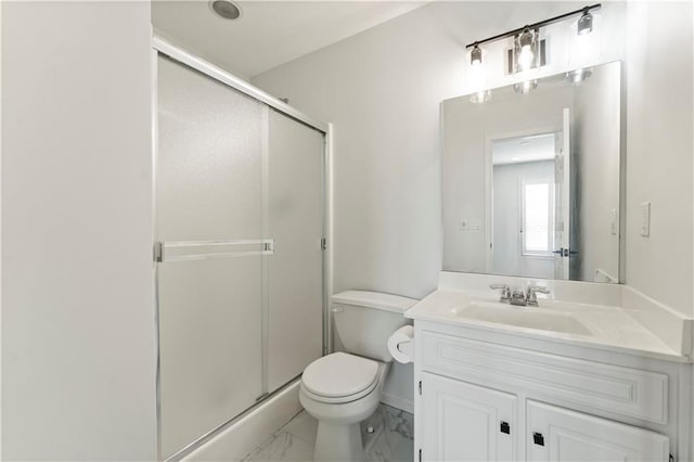 bathroom with a shower with door, vanity, and toilet