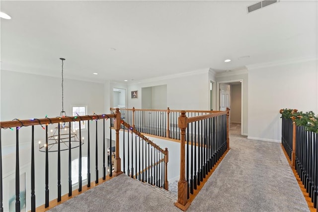 hall with crown molding, light colored carpet, and a notable chandelier