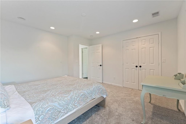 bedroom featuring light colored carpet and a closet