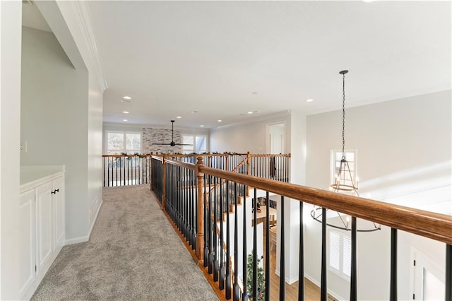 hallway with light colored carpet and crown molding