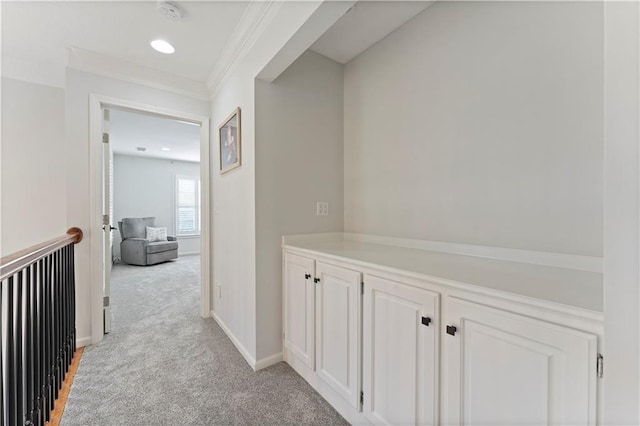 hall with light colored carpet and ornamental molding