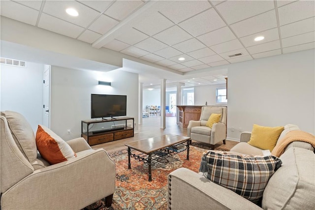 living room with a paneled ceiling and hardwood / wood-style floors