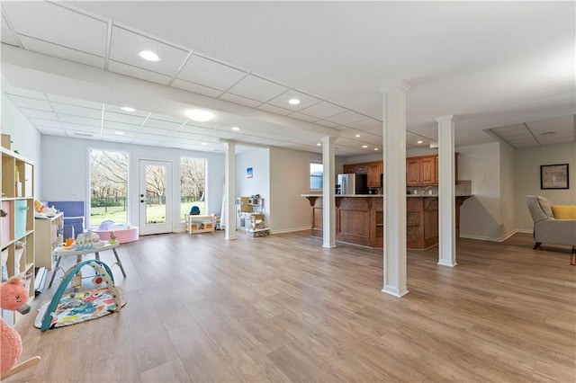 interior space with a drop ceiling and light hardwood / wood-style floors